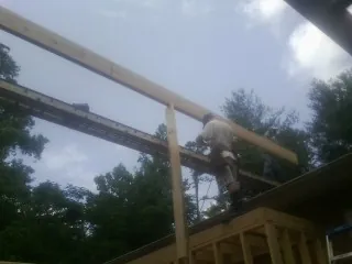 Carpenter setting a ridge beam over a new addition frame — Ice Dam Removal by Roofing Brothers in Mapleville
