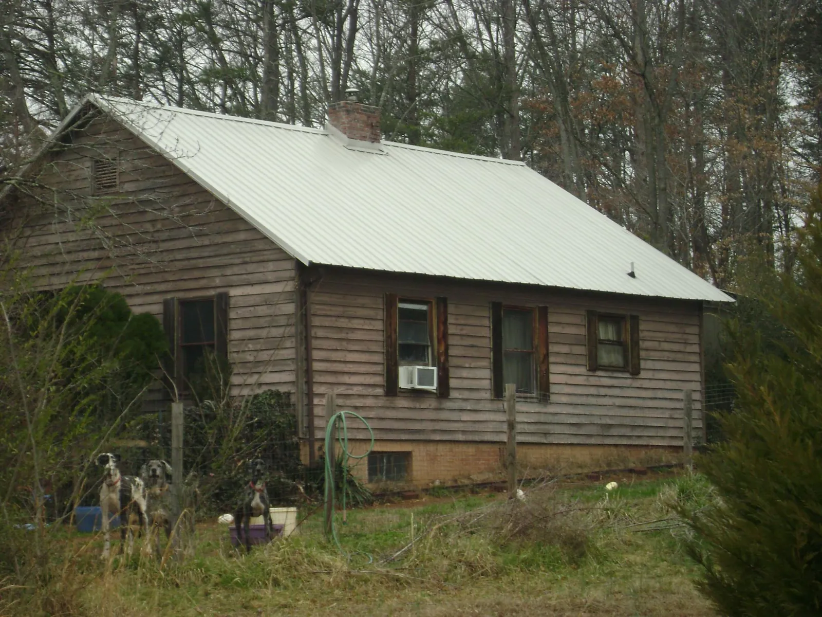 White metal roof on an old wood sided farmhouse, from a Metal Roof Installation job in Mapleville